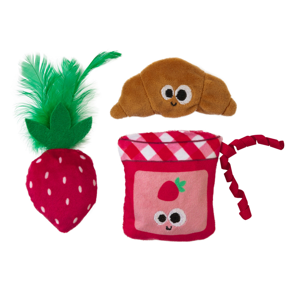The Mad Cat Kitty Croissant 3 Pack⢠by Mad Cat includes three plush toys: a strawberry with green feathers, a smiling croissant, and a pink jam jar with strawberry prints. Each vibrant, catnip-infused toy features playful expressions to entertain your feline friend.
