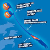A Chuckit! 22M Double Launcher Dog Toy features an ergonomic grip with two ball holders. Labels highlight: Double cups for double fetch, Slobber-Free Pickup, Iconic shape for farther throw, and Great for pack play. Playful dog silhouettes are in the background.