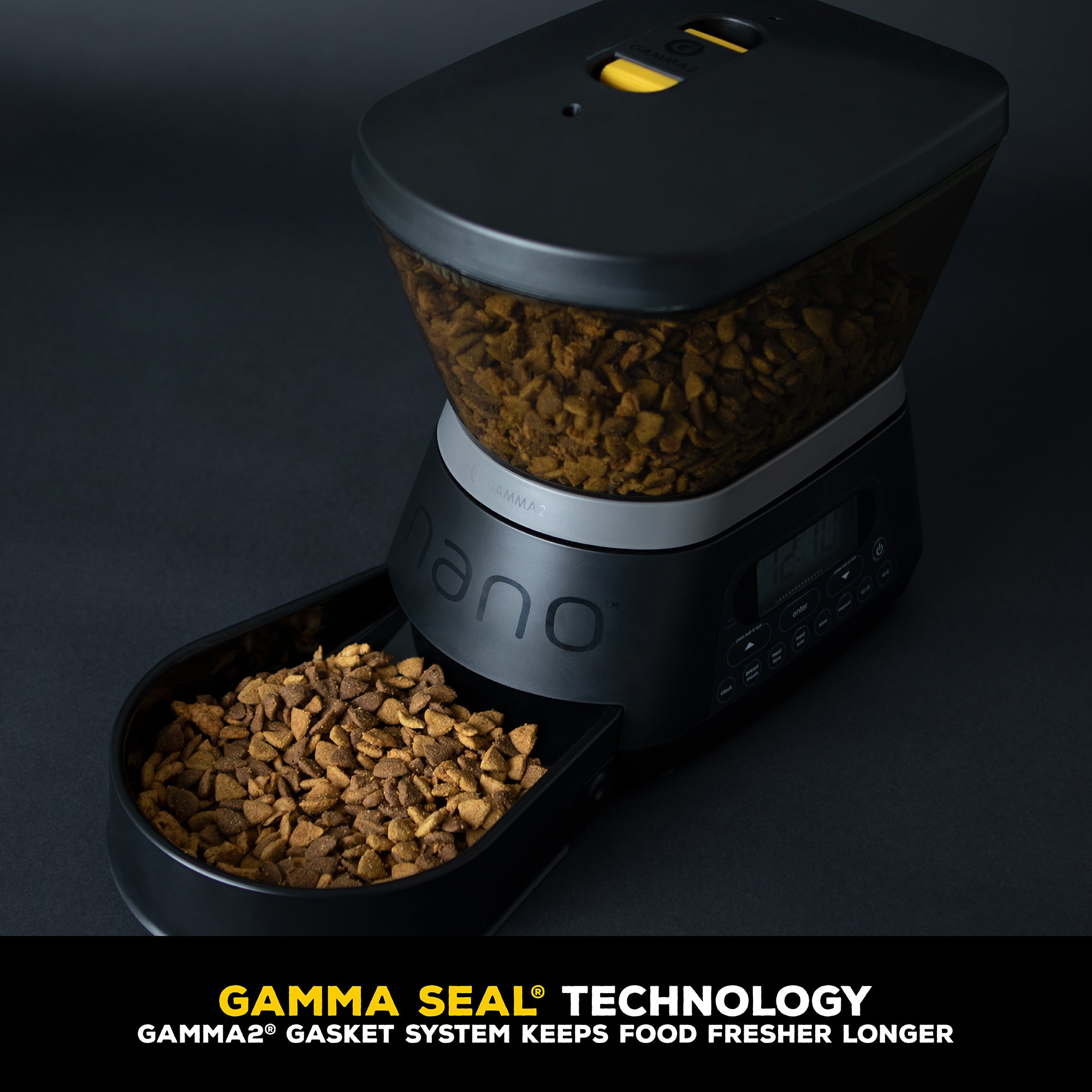 The GAMMA2 NANO Automated Pet Feeder by Gamma2 is a sleek black dispenser with a digital display at the base and a transparent hopper with a lid. Featuring Gamma Seal Technology, it automates feeding while keeping dry kibble fresh longer.