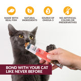 A gray cat enjoys a treat from the Wild Eats Simply Puree Variety Pack held in a persons hand. Icons above highlight omega-3, natural ingredients, and no artificial additives. Text reads: Bond with your cat like never before with this natural pet food.