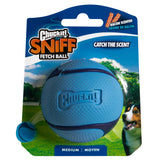 The Chuckit! Bacon Sniff Fetch Ball packaging features a medium-sized, durable blue rubber ball with an enticing bacon scent. Its showcased beside a dog photo in a park, with text stating Catch the Scent and Arome de Bacon, under the Chuckit brand name.