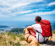 Man resting with his dog while on a hike