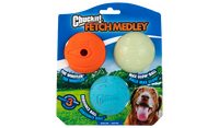 The Chuckit! Medium Fetch Medley Dog Ball Set includes the orange Whistler, glowing white Max Glow Ball, and bouncy blue Rebounce Ball. The packaging features a dog eagerly anticipating play, captured in the bottom right.