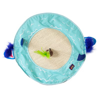 The Mad Cat Desert Island 20 Large Play Mat features a circular sisal scratching area, turquoise fabric with wave patterns, and a green feather wand toy. Blue fabric accents and attached feathers create an engaging play mat experience resembling ears.