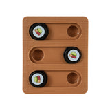 The Quirky Kitty Sushi Bento Box Puzzle Cat Toy features a brown wooden board with three sliding tracks and four black circular pieces, each adorned with a cupcake design. Two tracks contain two pieces, while one track is left empty to challenge feline cognition.