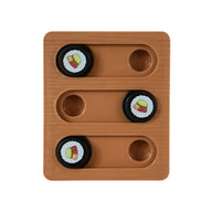 The Quirky Kitty Sushi Bento Box Puzzle Cat Toy features a brown wooden board with three sliding tracks and four black circular pieces, each adorned with a cupcake design. Two tracks contain two pieces, while one track is left empty to challenge feline cognition.