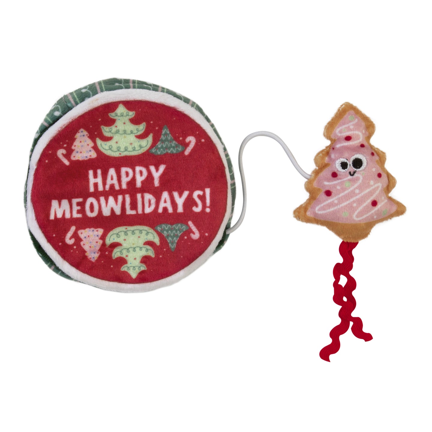 The Mad Cat Holiday Cookie Tin Hide A Toy is a round cat toy featuring Happy Meowlidays! text and small Christmas tree graphics. It includes a plush, smiley-faced tree-shaped toy with red curly string, perfect for play or as a holiday treat for your feline friend.