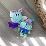 Quirky Kitty Luna Bugs 2pk glow-in-the-dark cat toys feature a light blue bug and blue-green fish, both with catnip and silvervine. These whimsical, forest-inspired toys add fun to your cat's playtime.