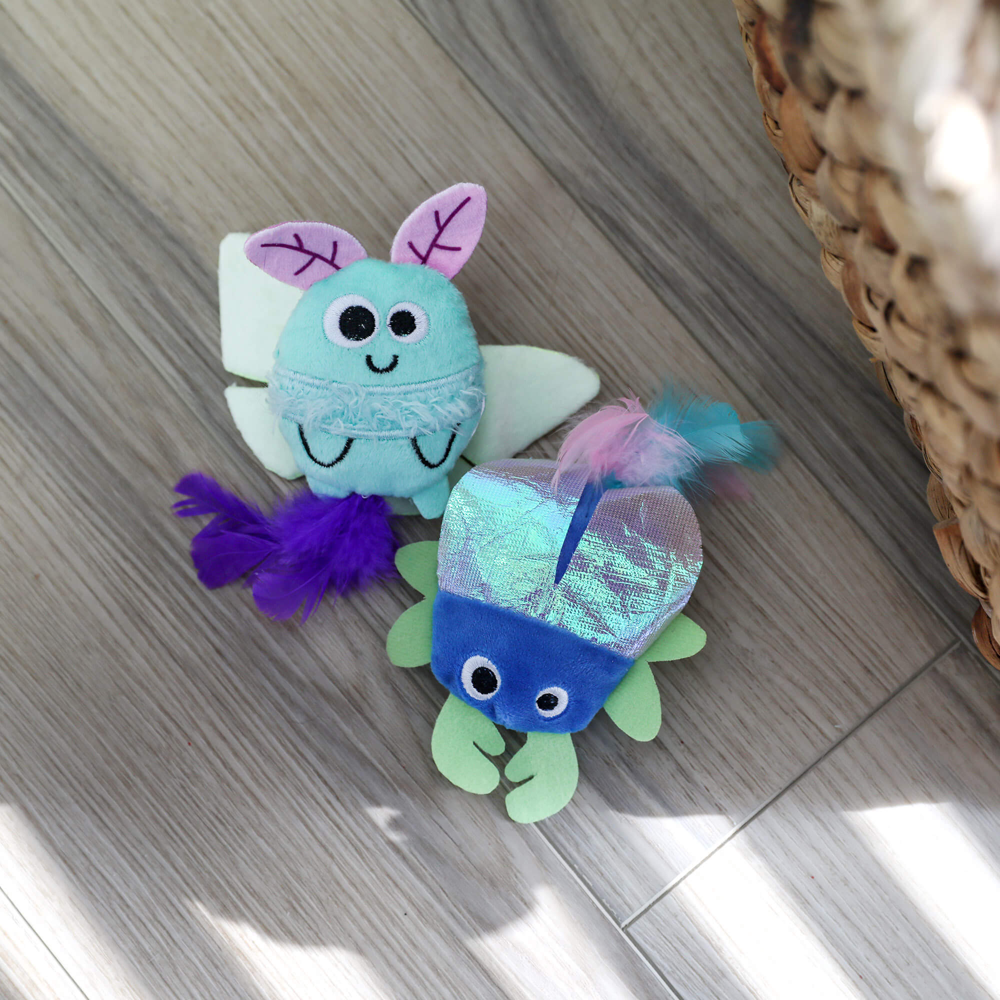 Quirky Kitty Luna Bugs 2pk glow-in-the-dark cat toys feature a light blue bug and blue-green fish, both with catnip and silvervine. These whimsical, forest-inspired toys add fun to your cat's playtime.