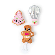 Quirky Kitty® Baking Spirits Bright 3-Pack Cat Toys: a pink frosted cookie, a silver kitchen whisk, and a gingerbread man with a bowtie and the text OH SNAP! printed on his chest.