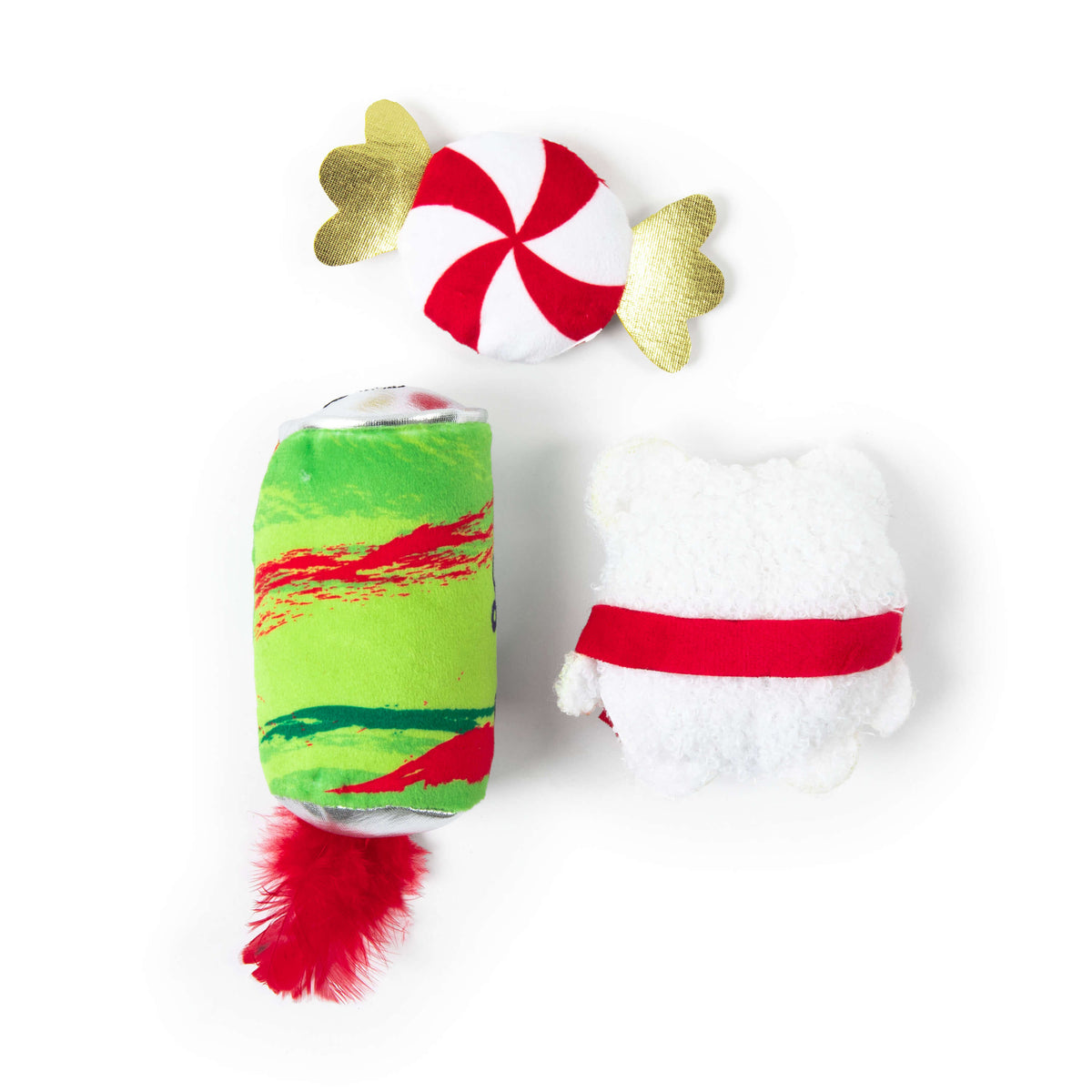 Three Quirky Kitty® Fa La La La Meowx 3-Pack cat toys: a candy-shaped toy with gold foil ends, a green and red cylindrical toy with a red feather, and a white, bear-shaped toy with a red sash.