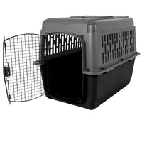 The Aspen Pet Pet Porter, by Aspen Pet, is a dark gray plastic carrier featuring a secure metal wire door. It opens to reveal its spacious interior, is designed for pet travel with ventilation holes on the sides and top, and rests elegantly on a white background.
