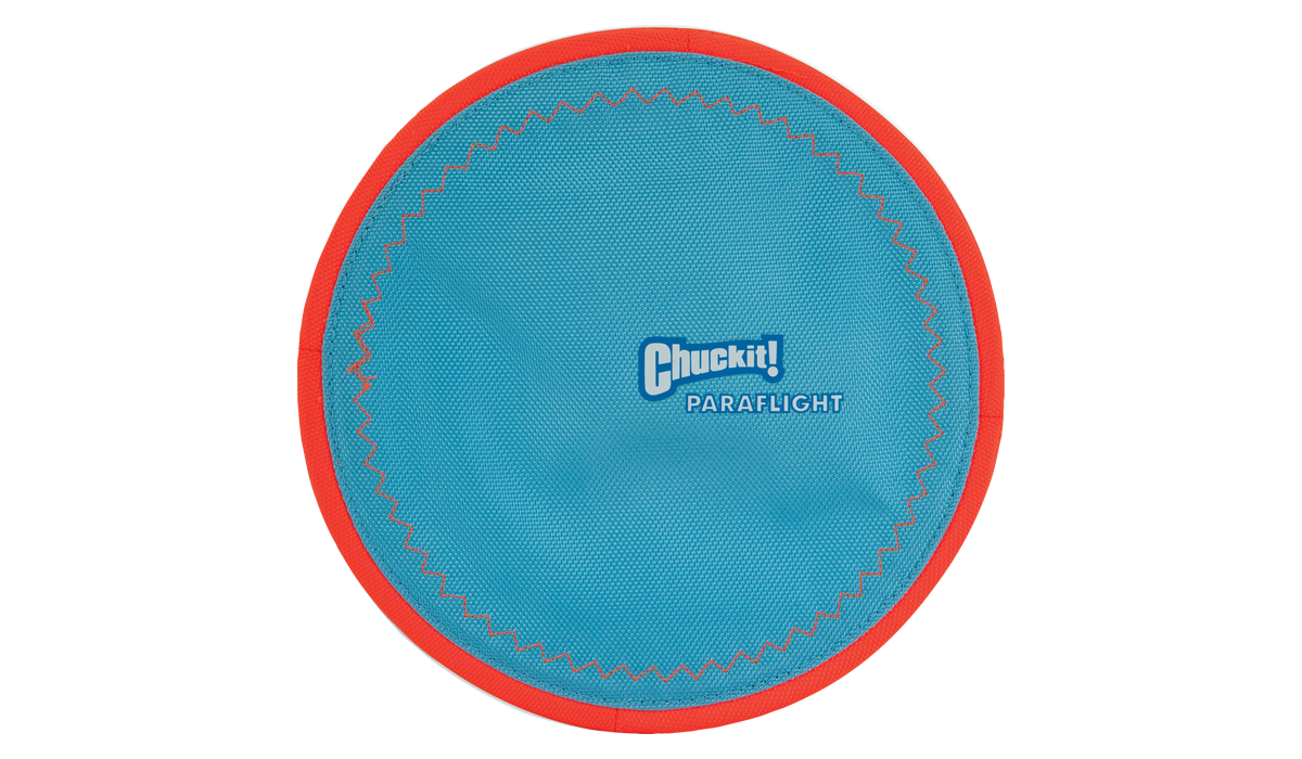 The Chuckit Paraflight Flyer Dog Toy, with its sleek round design, features a blue surface accented by red edging and zigzag stitching. Durable and entertaining, Chuckit! Paraflight Flyer is printed in white at the center, offering endless fun for your playful pup.