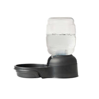 The Petmate Replendish 0.5 Gallon Filtered Pet Waterer by Petmate is a black plastic dispenser with a clear inverted bottle, offering automatic gravity refill for continuous pet hydration. Shown on a plain white background.