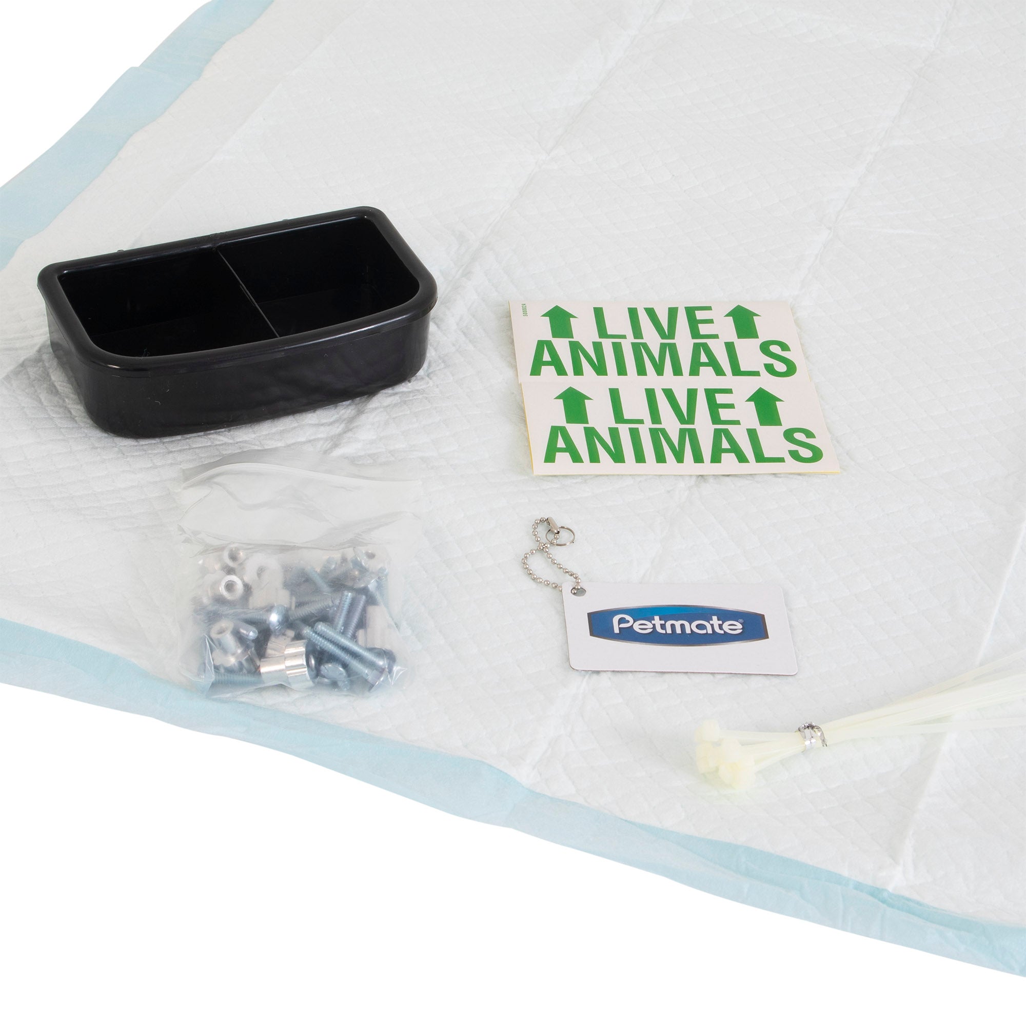 The Petmate Kennel Airline Travel Kit by Petmate is ideal for air travel, including a black dual-section dish, Live Animals stickers, a plastic bag with metal bolts and wing nuts, an ID tag with chain, zip ties, and kennel accessories all organized on a disposable pet pad.