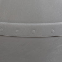 Close-up of the Petmate Husky Dog House by Petmate, showcasing a metallic surface with a lightly brushed texture and a curved seam accented by evenly spaced rivets for an industrial look.
