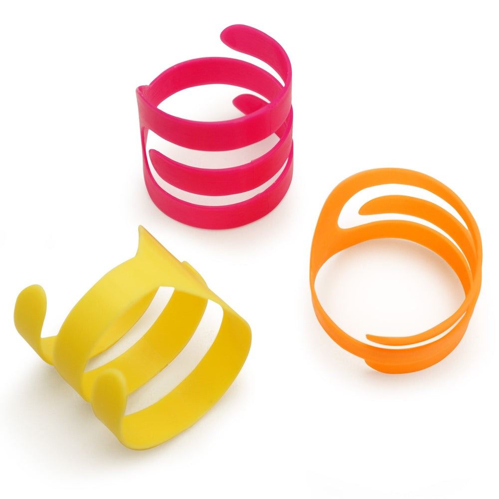 A white background displays three vibrant, flexible Petmate Looney Loops cat toys. These open-ended rings, in modern curved designs, feature bright neon colors: red, yellow, and orange.