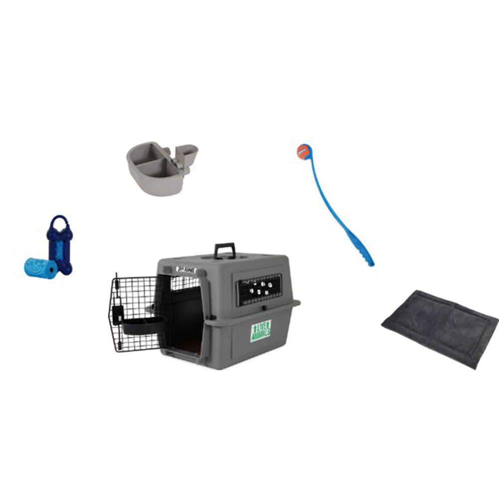 The Petmate Essential New Dog Bundle includes a gray pet carrier with an open wire door, a portable water bottle, dual food bowl, ball launcher with ball, waste bag set, and is accompanied by a cozy black pet bed.