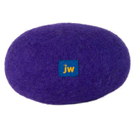 This oval-shaped dog toy, resembling a rock or cushion, is made of purple felted wool and features a small blue square tag labeled jw. Crafted like the JW Wool-ee Football, its antimicrobial properties make it an ideal choice for pets.