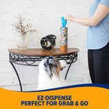 A person pulls a blue fresh-scent bag from the patterned Arm & Hammer Gotta Go Waste Bag Dispenser on a table, while a dog watches. Text below reads, EZ-Dispense Perfect for Grab & Go.