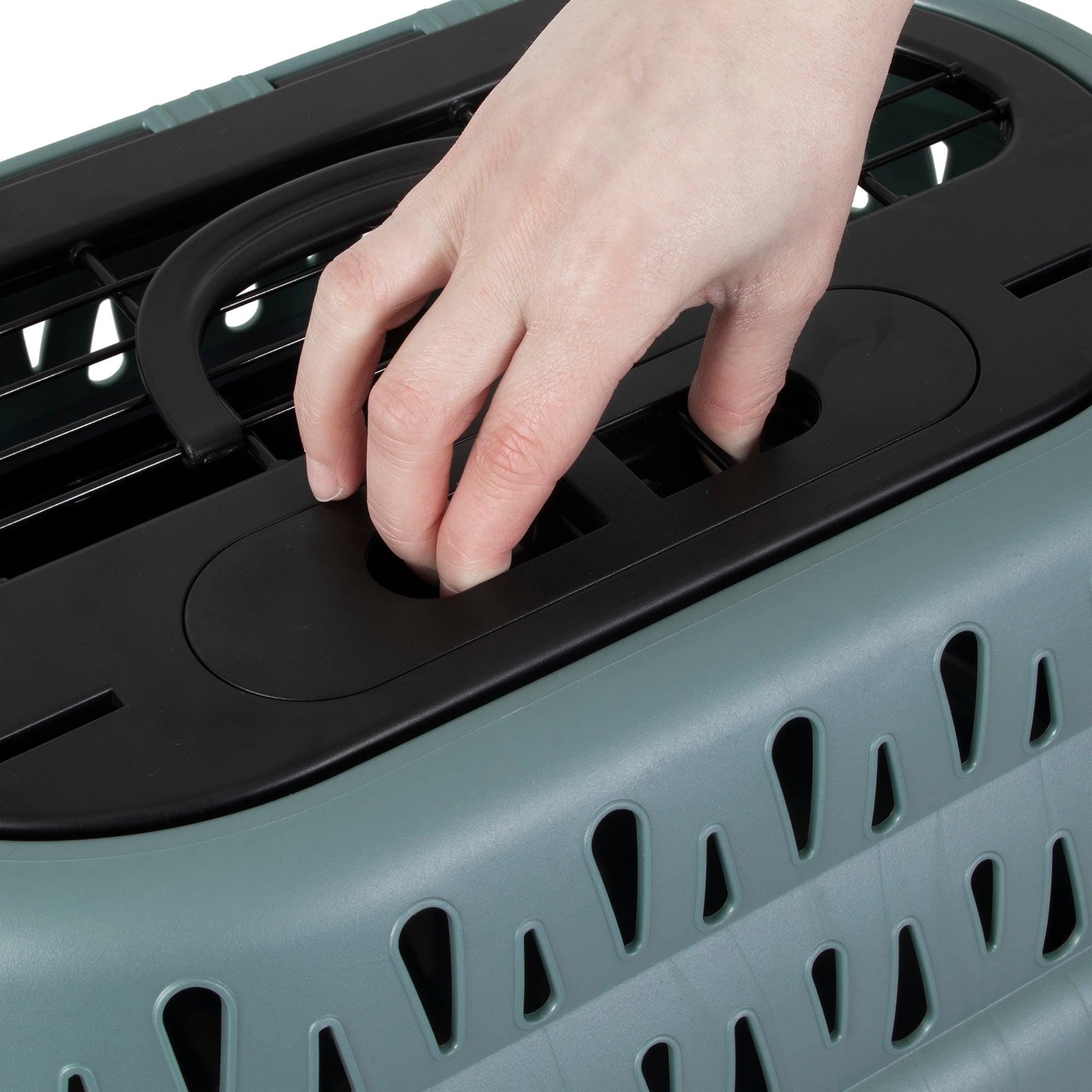 A hand adjusts the handle on a Petmate Top Load Cat Kennel lid, which features ventilation openings along the sides. The top has a black section with a slot for securing the handle.