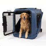 A golden retriever sits inside a Petmate Basecamp Travel Kennel, a durable blue hard-shell crate with an open wire door.