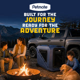 A durable hard-shell Petmate Basecamp Travel Kennel sits next to a campfire where a family and their dog are relaxing outdoors near a parked truck.