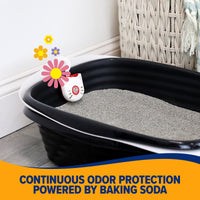 A black litter box with gray litter includes a small device featuring a cat face design. Set against white walls and near a wicker basket, it offers Continuous odor protection powered by Arm & Hammer Purifying Pak Cat Litter Deodorizer from Arm And Hammer.