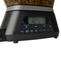 The GAMMA2 NANO Automated Pet Feeder by Gamma2 displays 12:57 on its screen. The control panel includes buttons for clock, preset meals, and meal size. Kibble is visible in the container, making this dispenser an efficient solution for simplifying pet feeding routines.