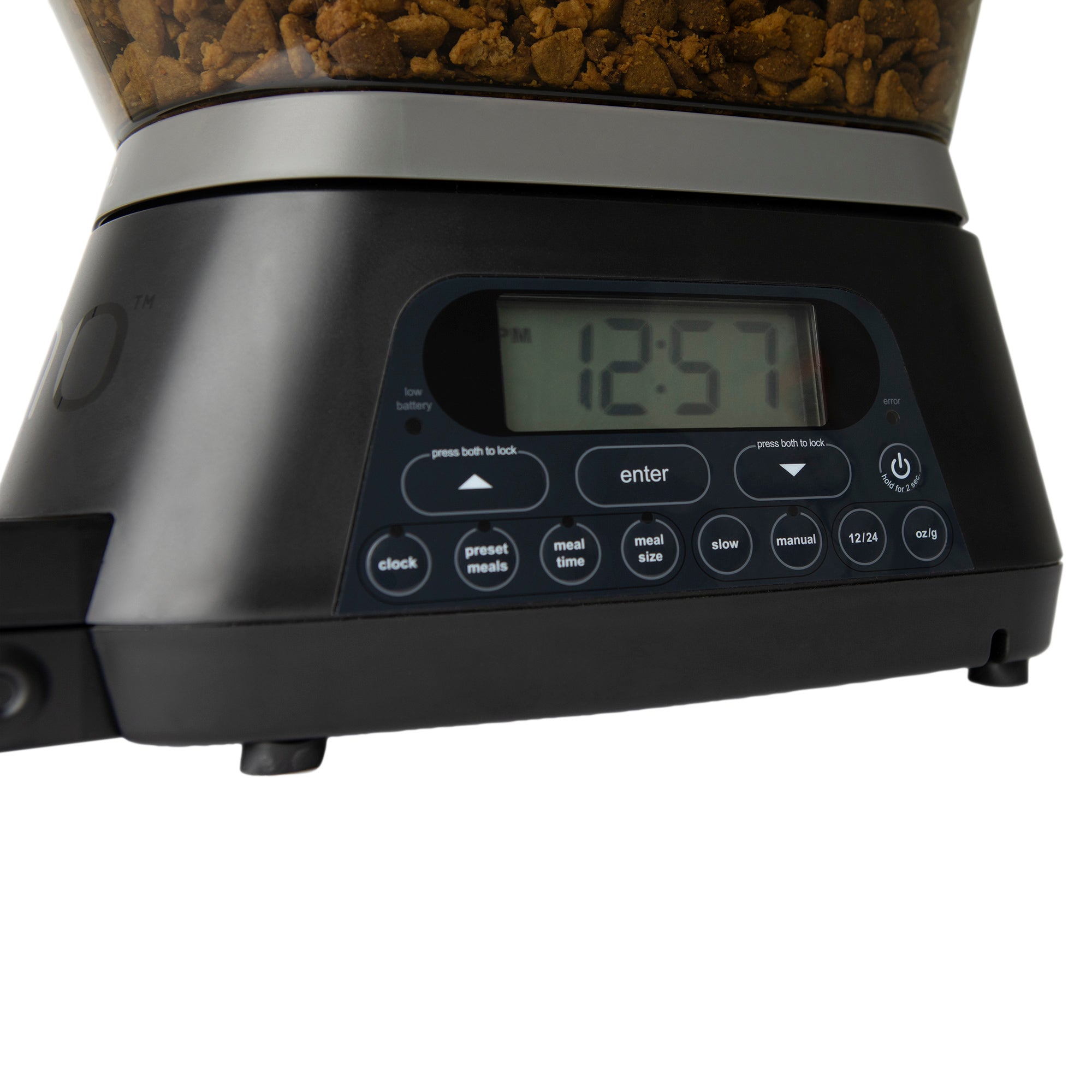 The GAMMA2 NANO Automated Pet Feeder by Gamma2 displays 12:57 on its screen. The control panel includes buttons for clock, preset meals, and meal size. Kibble is visible in the container, making this dispenser an efficient solution for simplifying pet feeding routines.