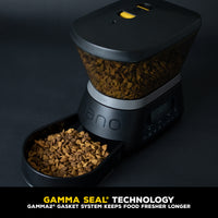 The GAMMA2 NANO Automated Pet Feeder by Gamma2 is a sleek black dispenser with a digital display at the base and a transparent hopper with a lid. Featuring Gamma Seal Technology, it automates feeding while keeping dry kibble fresh longer.