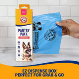 A person pulls a blue waste bag from an Arm & Hammer Pantry Pack Waste Bags 300 ct. box, featuring activated baking soda. The EZ Dispense Box, with a dog image, advertises Perfect for Grab & Go. White tiles and a countertop complete the tidy scene.