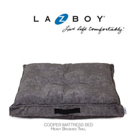 The La-Z-Boy Smoke Twill Cooper Mattress Dog Bed offers plush comfort with ComfortSelect fiberfill, heavy brushed twill, tufted details, and a black handle. Ideal for medium dogs, it prominently features the La-Z-Boy logo and Live life comfortably slogan.