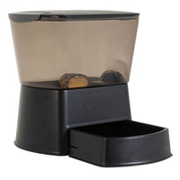 The Nano Click Manual Pet Feeder by Gamma2 boasts sleek black design with Gamma Seal Technology, a transparent food container, and an open tray at the bottom for easy access for your furry friend.
