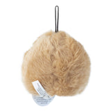 The Pet Qwerks Plush Chattering Hedgehog Dog Toy by Petqwerks is a round, light brown object with a short black string on top and a white tag. It resembles a small fluffy pillow or toy, making it ideal for cuddles and as a playtime companion.