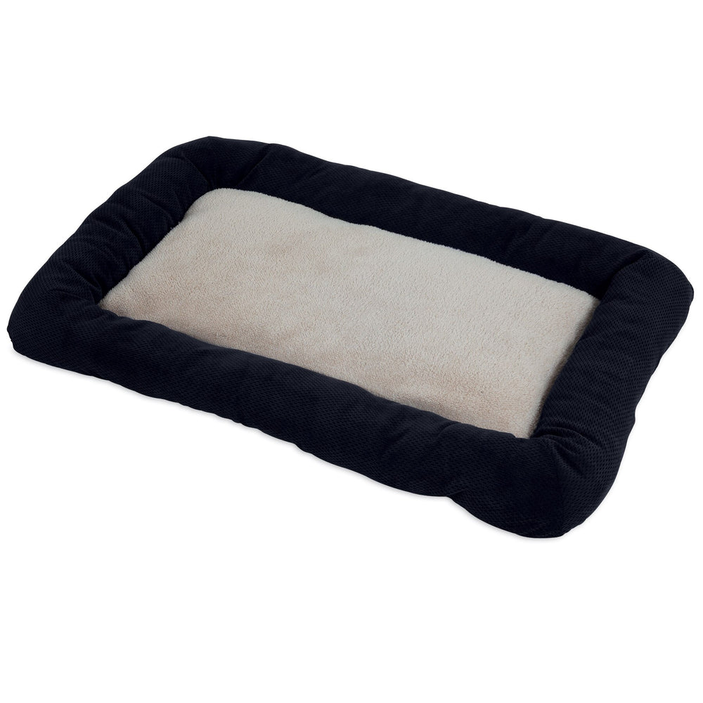 The SnooZZy Chenille Low Bumper Kennel Mat in black features a fluffy, light beige center cushion with a dark plush border. Designed for comfort and support, it fits wire dog kennels and is machine washable for easy care.