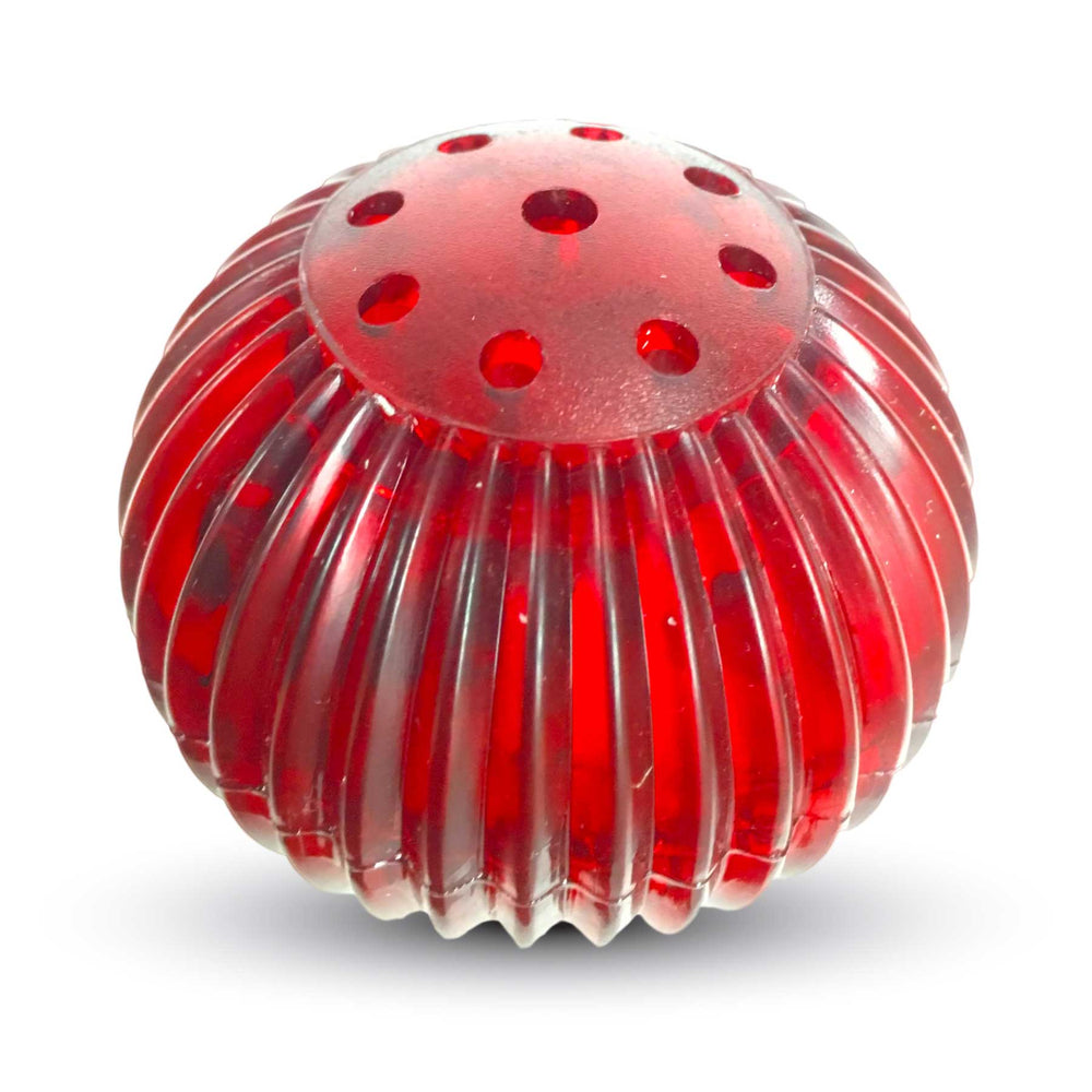 The image shows the Pet Qwerks Blinky Babble Ball, a round, red plastic toy with vertical ridges and small top holes. Made from high-impact ABS by Petqwerks, this engaging dog toy stands out against a plain white background.