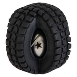 A close-up reveals a black rubber tire with rugged treads encircling a shiny metal sphere with a star-shaped cutout, resembling the Pet Qwerks Jingle X-Tire Ball by Petqwerks. This design contrasts matte rubber and reflective metal for an eye-catching pet toy.