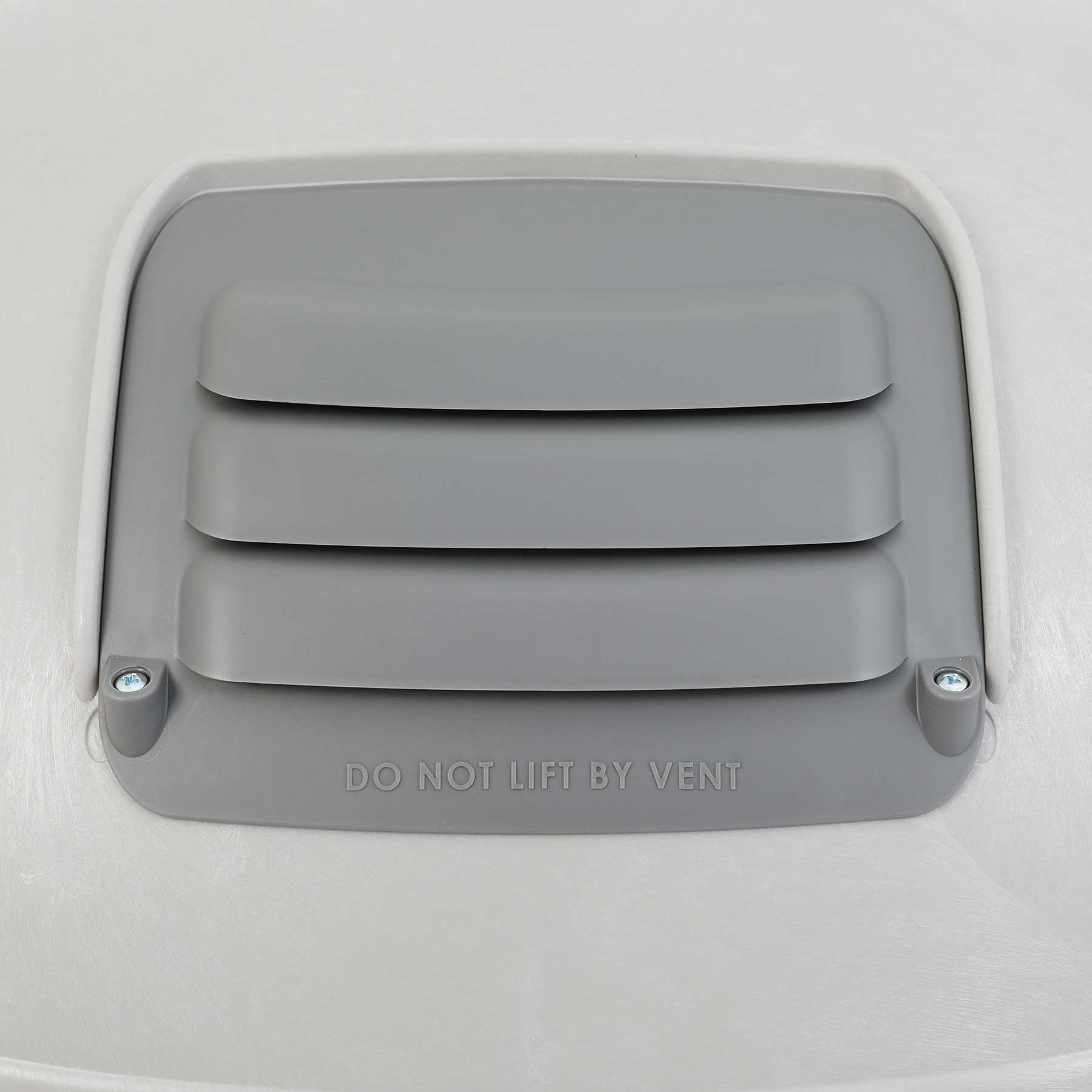 The Petmate Husky Shelter Vent Kit features a gray cover with horizontal slats, DO NOT LIFT BY VENT embossed below, and is secured with two screws on a smooth, light-colored surface to ensure your pets safety.