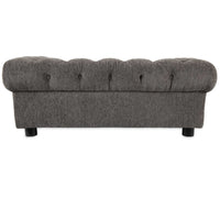 A gray upholstered bench with a tufted top and rounded edges, similar to a La-Z-Boy Newton Sofa Dog Bed. It features a plush design with button details, wrapped in textured chenille, and rests on short black legs.