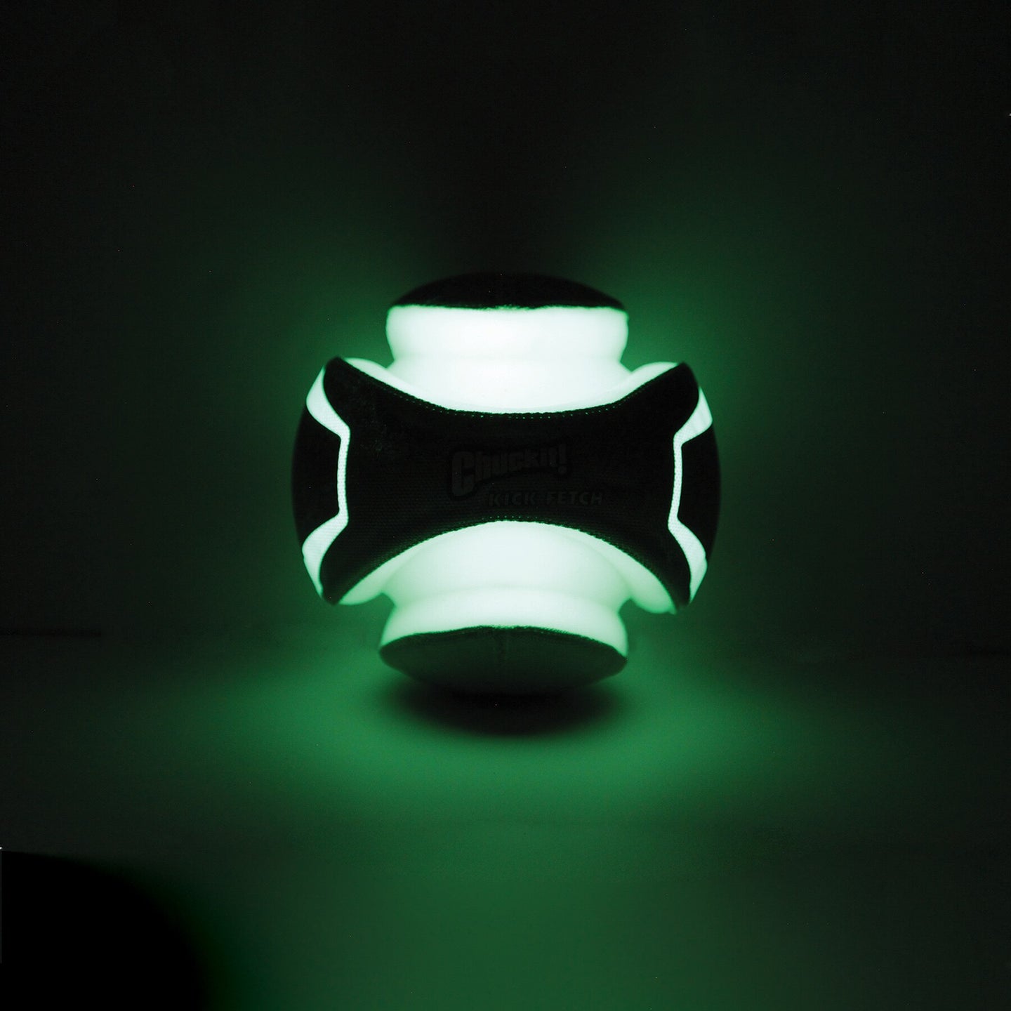 The Chuckit! Kick Fetch Max Glow by Chuckit is a glowing green rubber dog toy ball with black X-shaped sections, made from photoluminescent material. Its white glow-in-the-dark parts emit a soft illumination, making it ideal for interactive nighttime play.