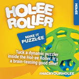 Bright ad for JW Hol-ee Roller Dog Toy: Features a natural rubber green hexagonal ball with a blue sphere puzzle inside. Text reads: Make it Puzzl-ee. Tuck a puzzler into the versatile Hol-ee Roller for brain-teasing fun! #HackYourHolee. Brand: JW.