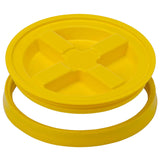 A yellow Gamma2 GAMMA Seal Lid, crafted from BPA-free HDPE plastic, includes a raised cross pattern and separate circular ring to provide an airtight seal for buckets or containers.