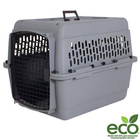 The Aspen Pet Traditional Kennel features a gray design with a black metal door and ample ventilation slots, ideal for travel. It includes a top handle and has an eco logo in the bottom right corner, signifying its made from 90% pre-consumer recycled plastic.